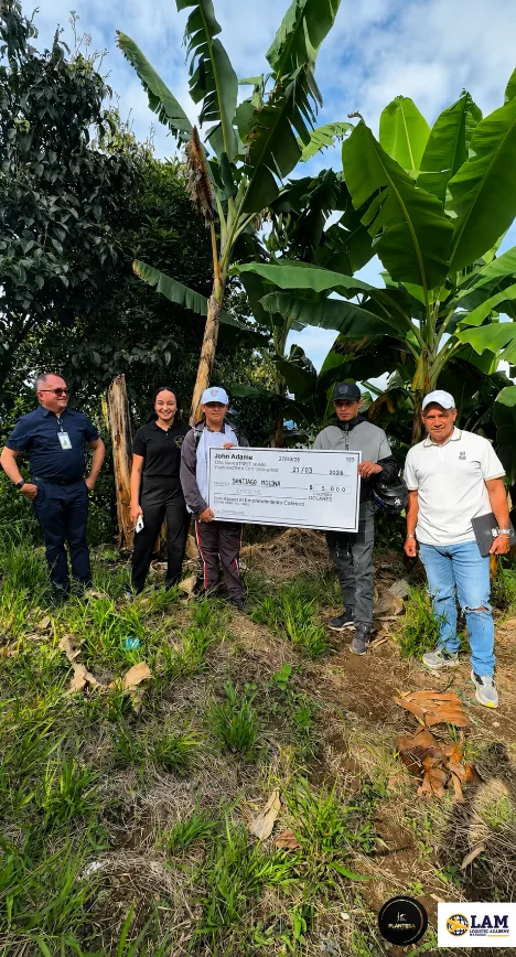 Personas en el cultivo con cheque de apoyo a La Granja del Futuro